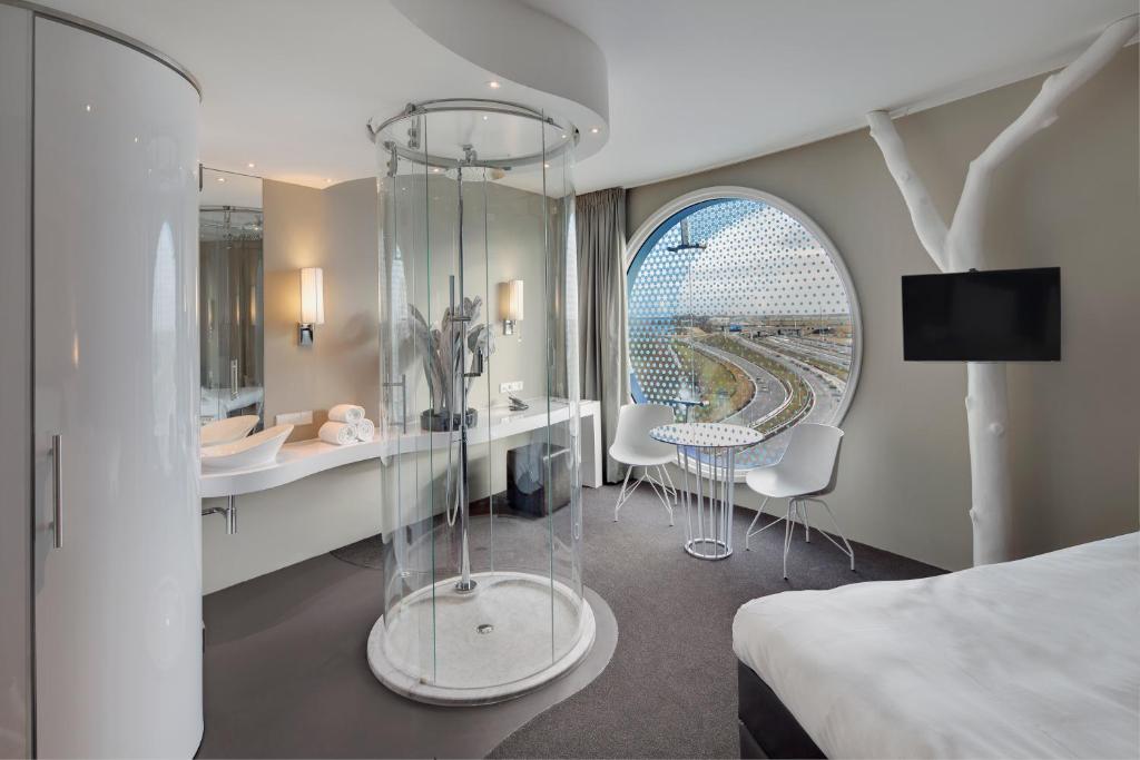 阿姆斯特丹阿姆斯特丹弗莱彻酒店的酒店客房带一张床、一张桌子和椅子