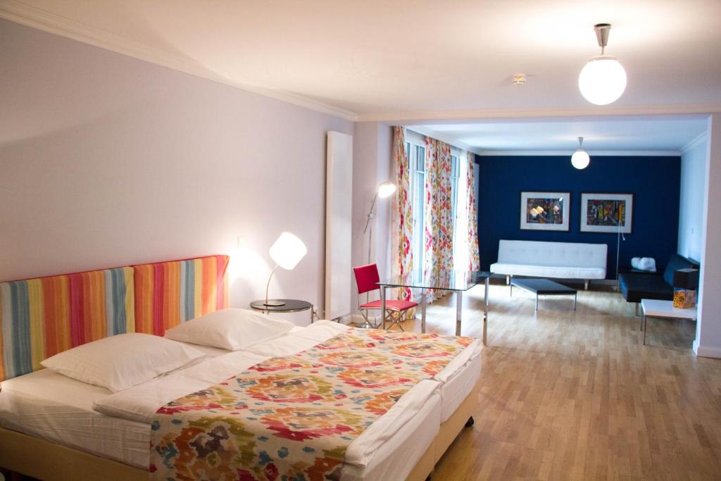 慕尼黑达斯慕尼黑酒店的一间卧室设有一张床和一间客厅。