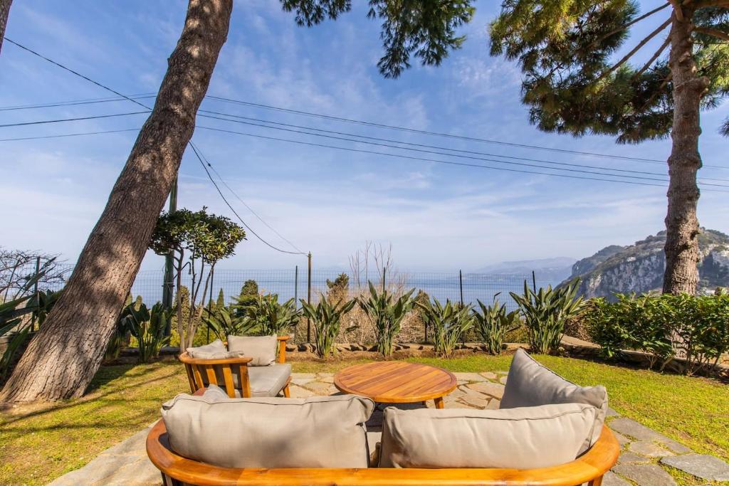 卡普里La Gioiella Capri的一个带桌椅的庭院和大海