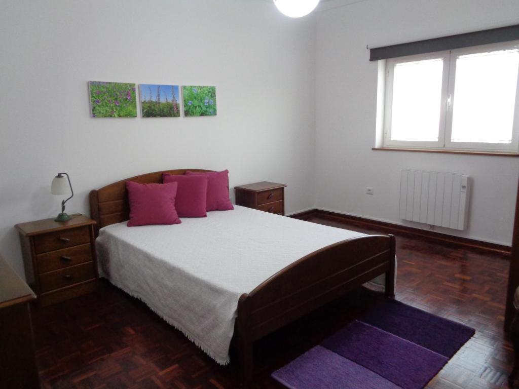 维拉·诺瓦·达·塞尔维尔Casa da Nanda的卧室配有一张带粉红色枕头的大床
