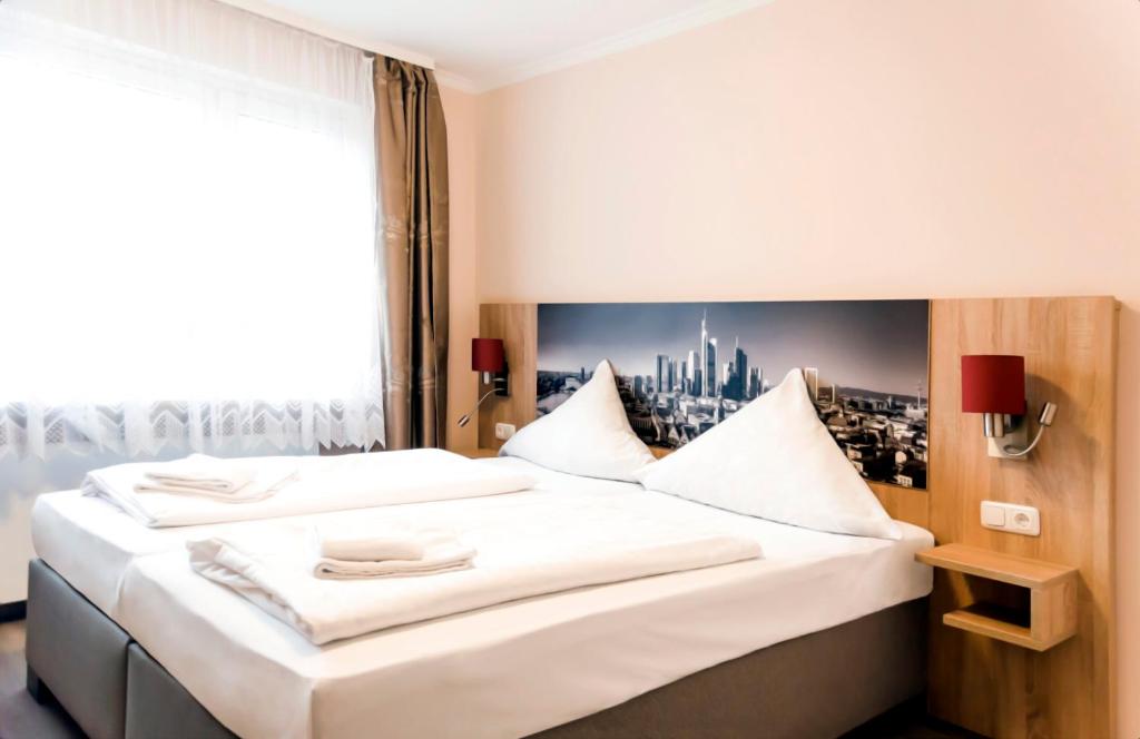 美因河畔法兰克福皇家酒店的卧室配有一张大白色床和窗户