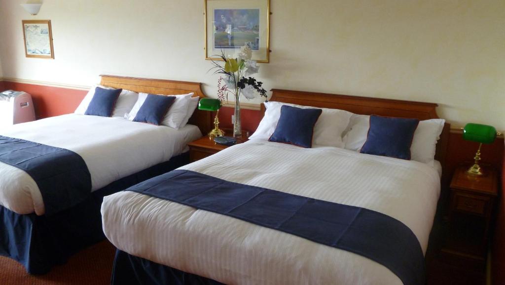 滕特登London Beach Country Hotel & Golf Club的酒店客房带两张带蓝白床单的床。