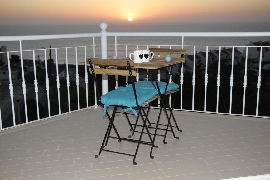 埃里塞拉Ericeira Sunset Apartment的海景阳台上的桌椅