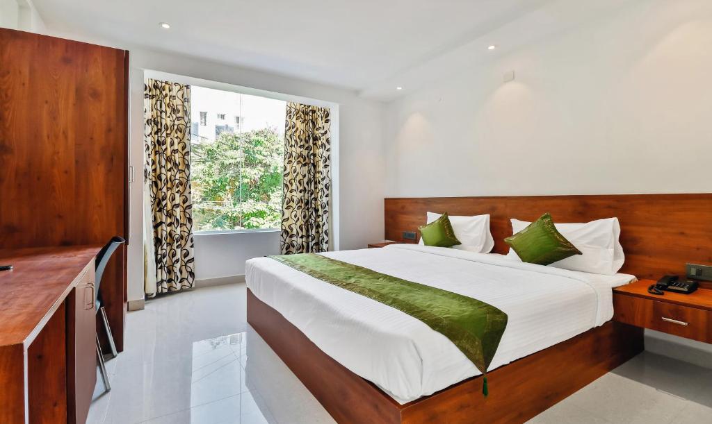 班加罗尔Treebo Trend Blu Orchid的一间卧室设有一张大床和一个窗户。