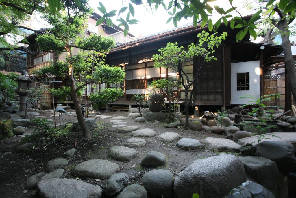 东京Guesthouse toco的一座岩石建筑前的花园