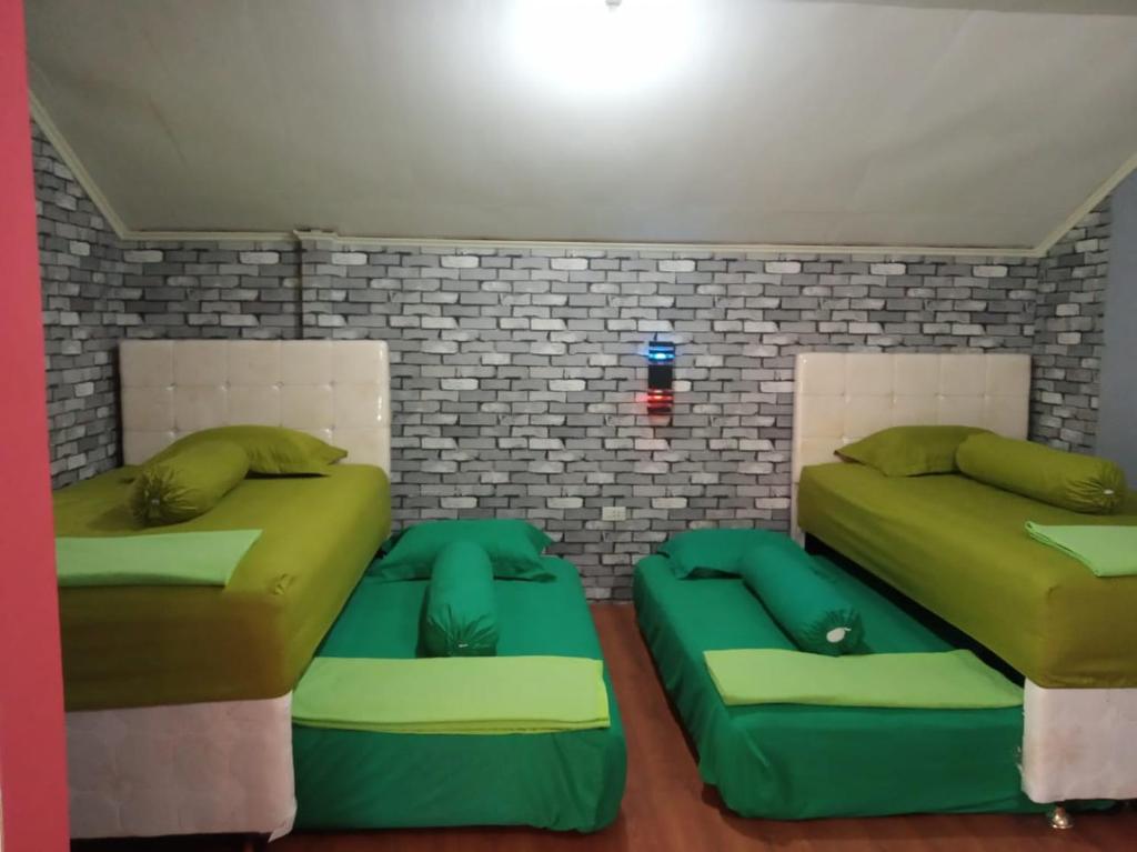 LasikinPondok Oma的两张带绿色枕头的床