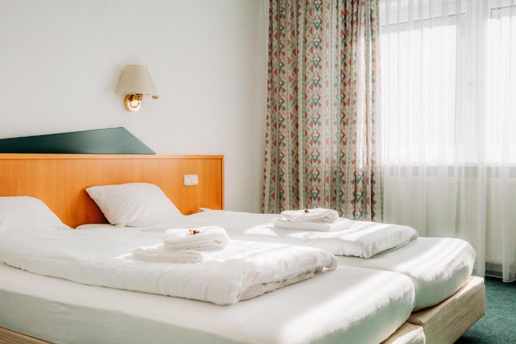 巴特哈尔茨堡Hotel Radau的两张位于酒店客房的床,配有毛巾