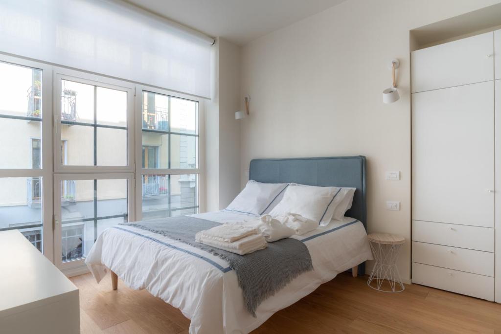 米兰Mini loft Moscova的白色的卧室设有床和大窗户