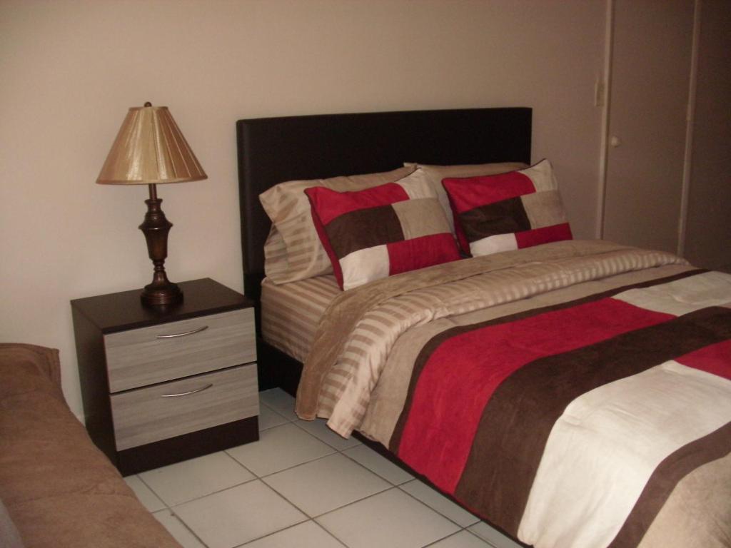 劳德代尔堡Newly Furnished Large, Clean, Quiet Private Unit的一间卧室配有一张床和一个带灯的床头柜