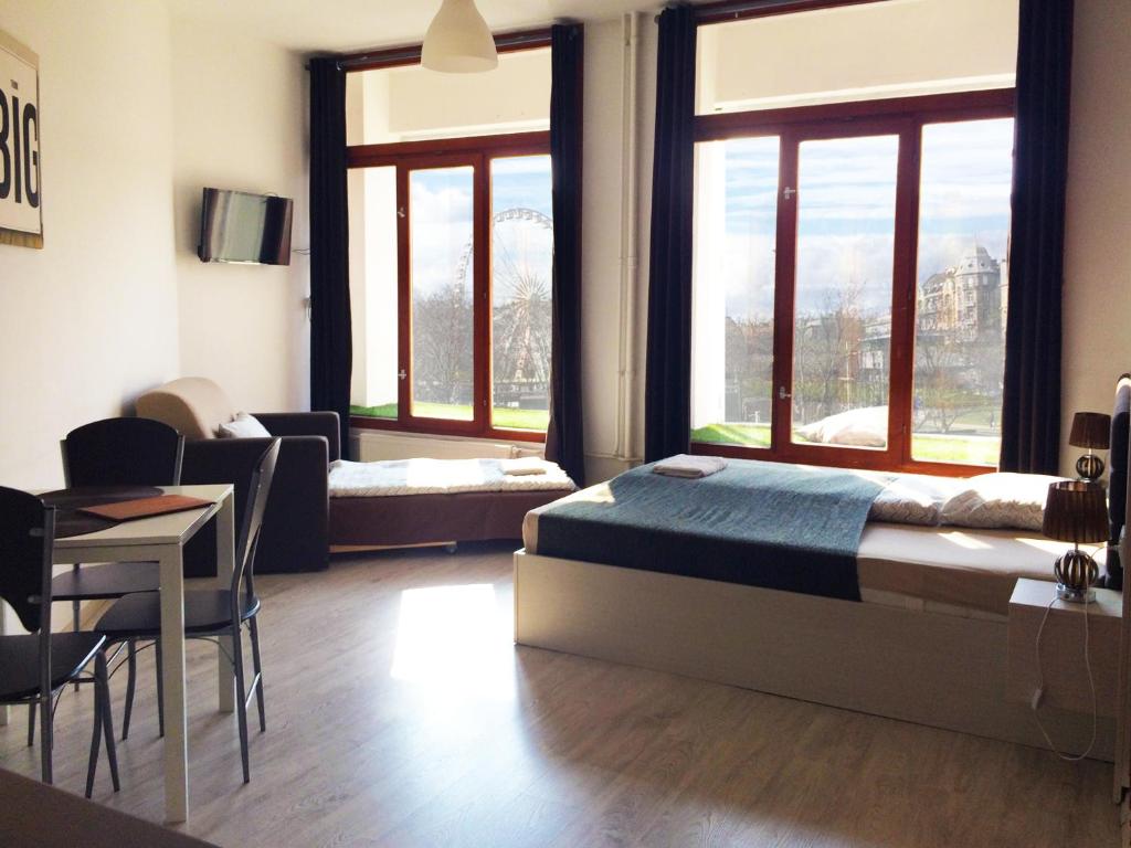 布达佩斯Zoom-Budapest Apartments的卧室配有一张床和一张桌子及椅子