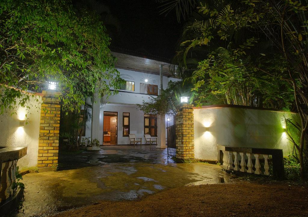 阿努拉德普勒Aura City Hostel的一座在晚上有长凳的建筑