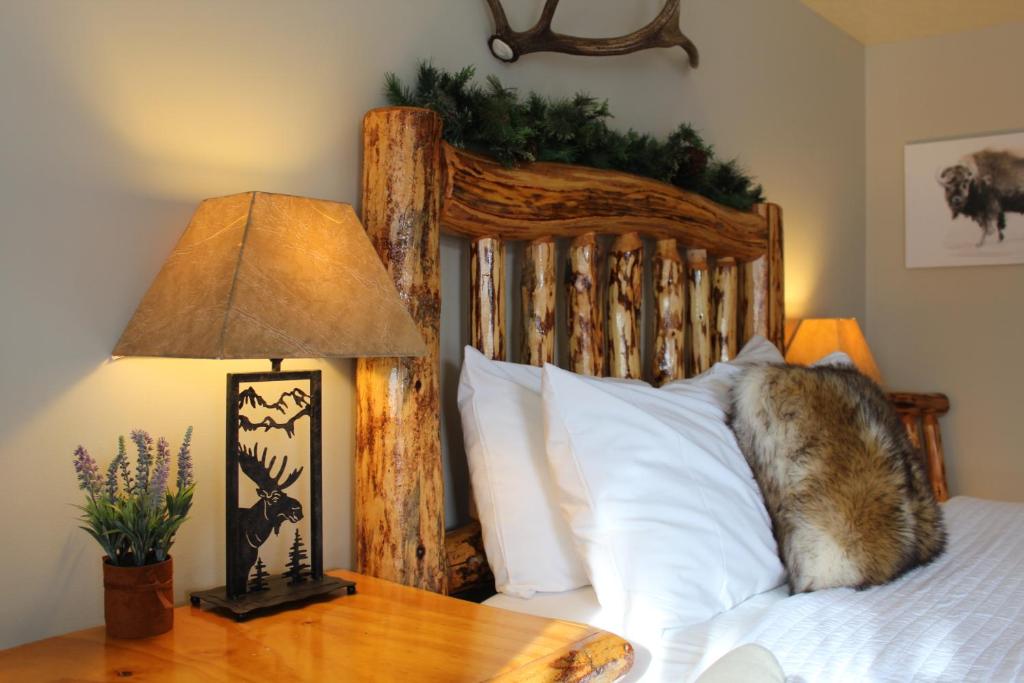 西黄石The Evergreen的一张带木制床头板的床和一张带台灯的桌子