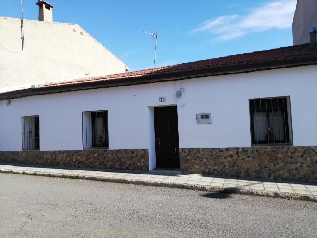 Navas de EstenaCasa Simona的街道上一扇黑色门的白色建筑