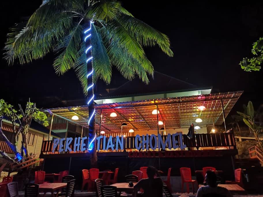 停泊岛Perhentian Chomel Chalet的夜晚餐厅前的棕榈树