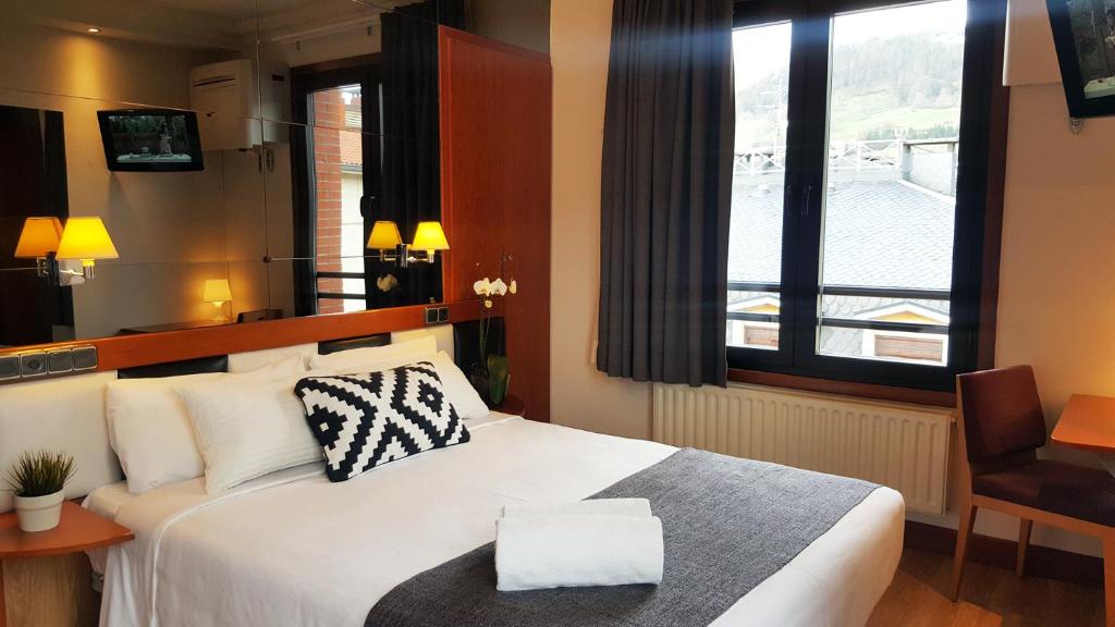 托洛萨奥里亚酒店的酒店客房设有白色的床和窗户。