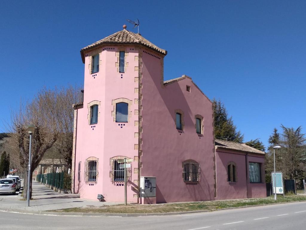 TonaTorre de la Ferrería的街道边的粉红色建筑