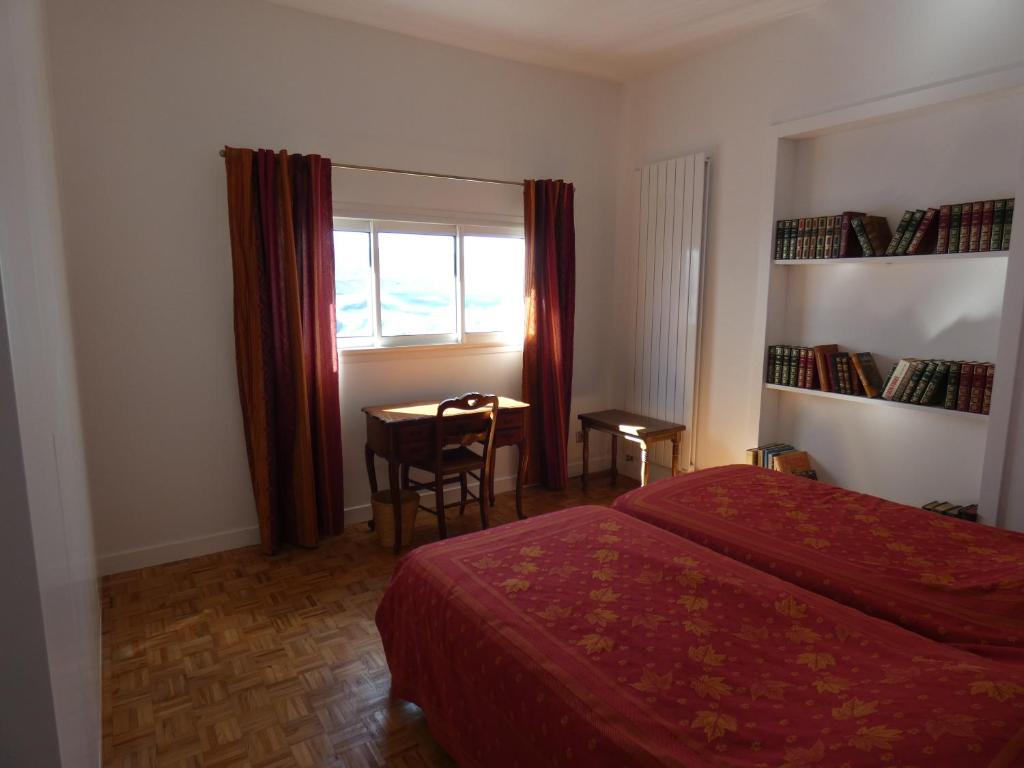 比亚里茨Maison Basque的一间卧室设有两张床、一张桌子和一个窗口