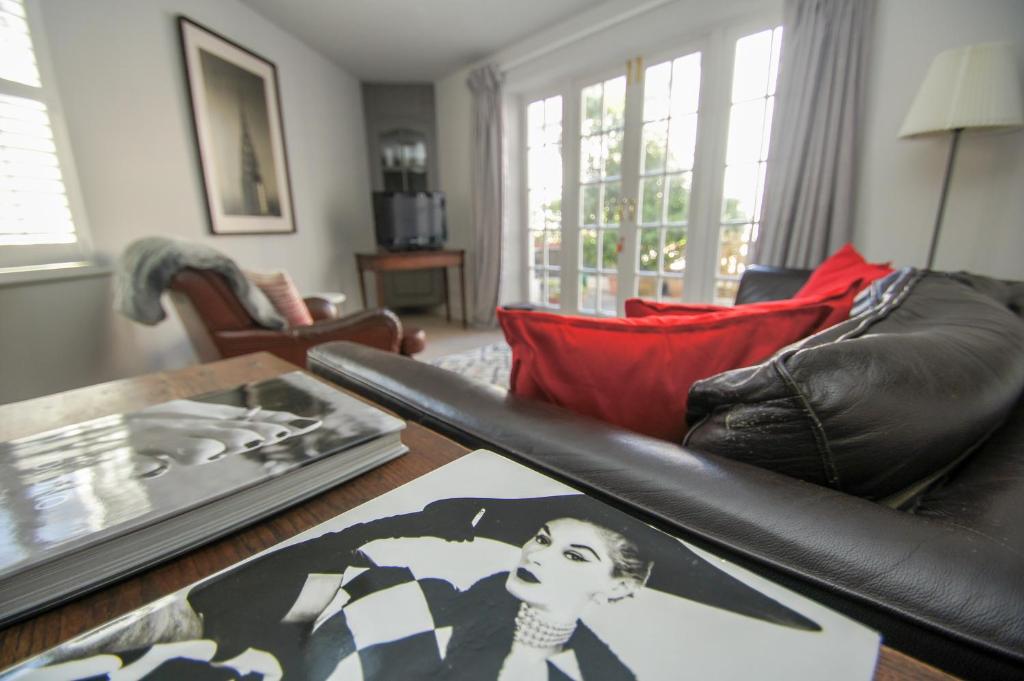 布莱顿霍夫Arundel Mews - Parking - by Brighton Holiday Lets的客厅配有黑色真皮沙发和桌子