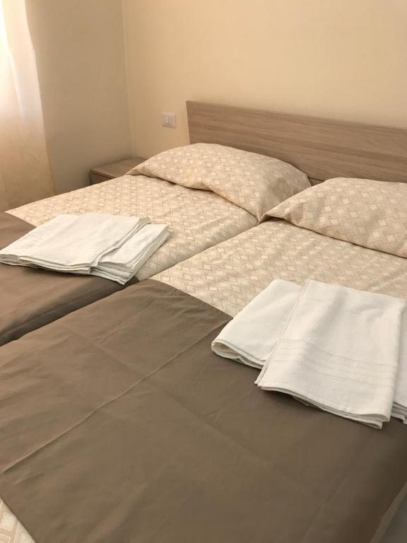 卡尔塔尼塞塔B&B Trieste Caltanissetta的一张带白色床单和枕头的床