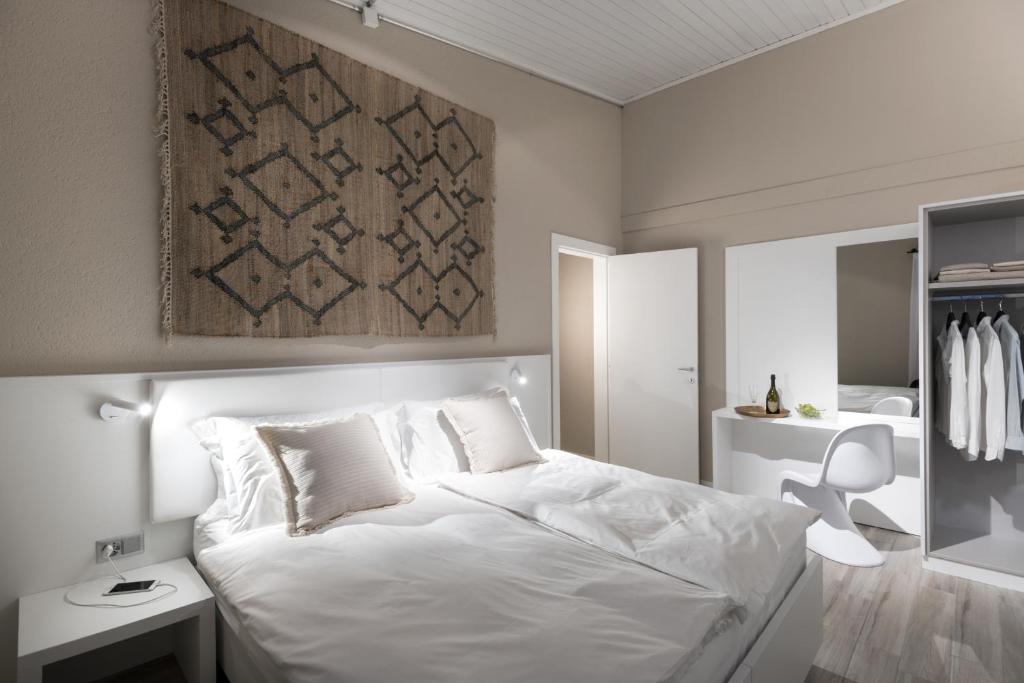 TaverneCP Resort的卧室配有一张白色大床和镜子