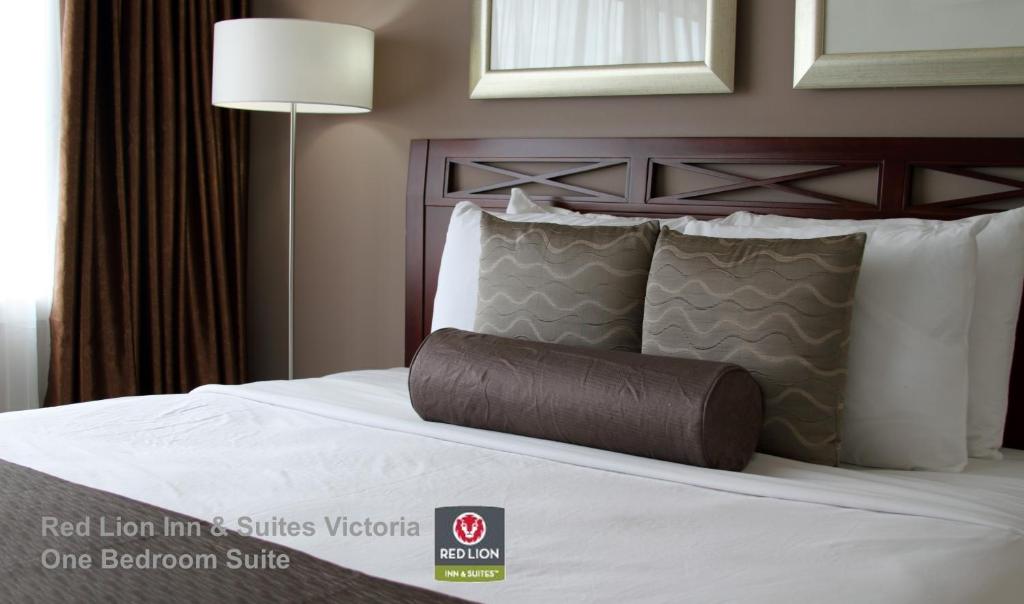 维多利亚维多利亚红狮套房酒店的一张位于酒店客房内的床铺,配有棕色枕头