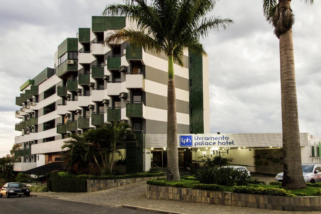 维多利亚-达孔基斯塔Livramento Palace Hotel的街道前方有棕榈树的建筑