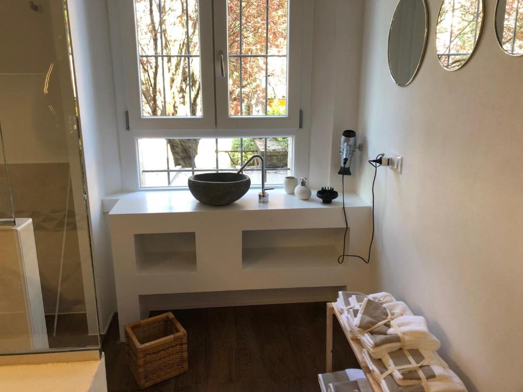 费拉拉Un Piccolo Rifugio的一个带窗户的柜台上带水槽的浴室