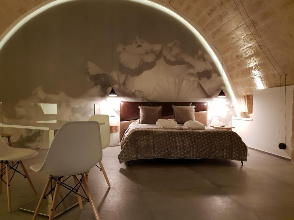 格拉维纳普利亚Le Fornaci Imperial Lodge & Spa的卧室配有一张床和一张桌子及椅子