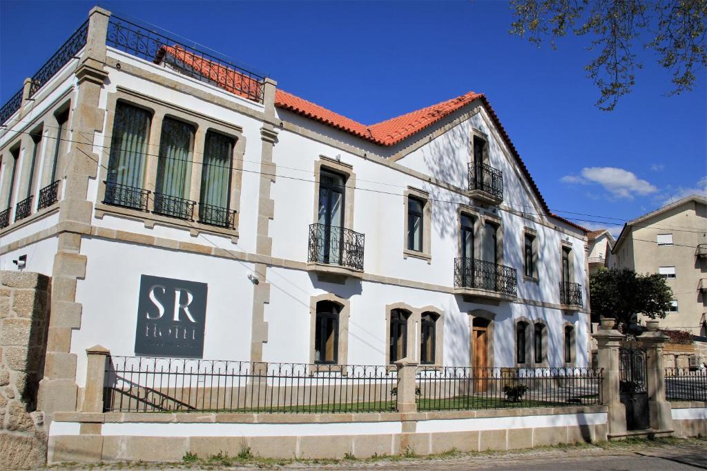 奥利维拉多霍斯比托Hotel Solar do Rebolo的一座白色的旧建筑,上面有标志