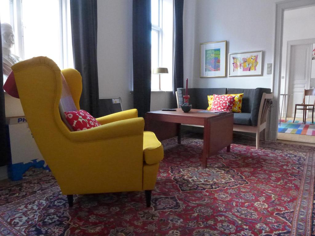 里伯Sortebrødregade Ferielejligheder的客厅配有黄色椅子和桌子
