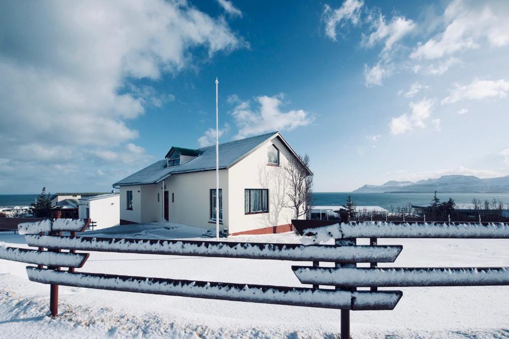 欧拉夫斯维克Experience Beautiful Iceland的雪中的房子,前面有长凳
