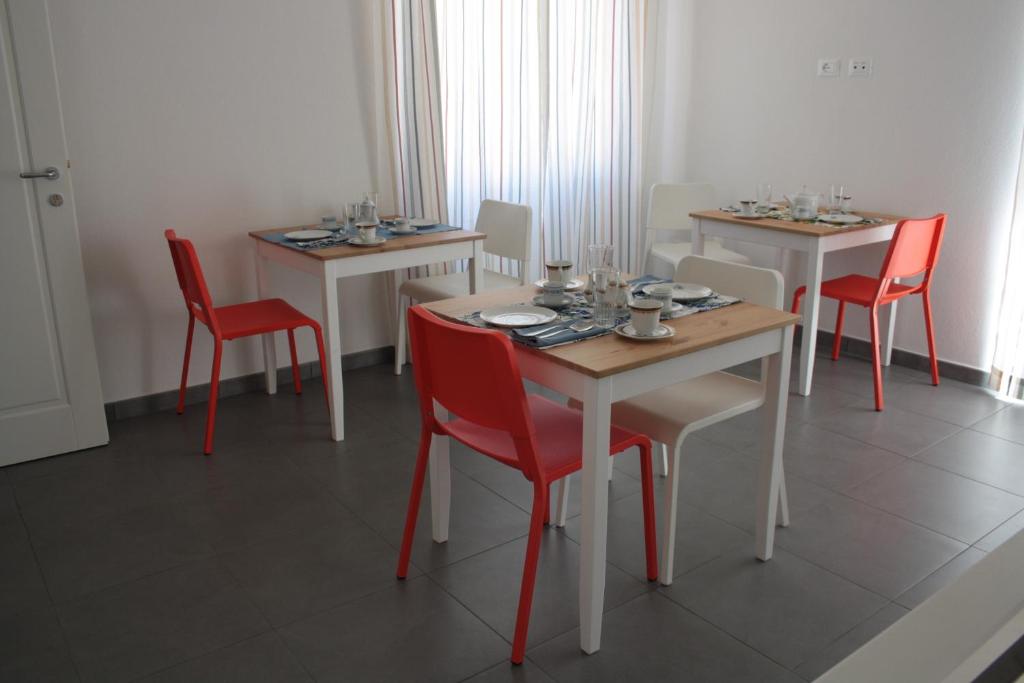 奥列纳Gli olivi的一间设有四张桌子和红色椅子的用餐室