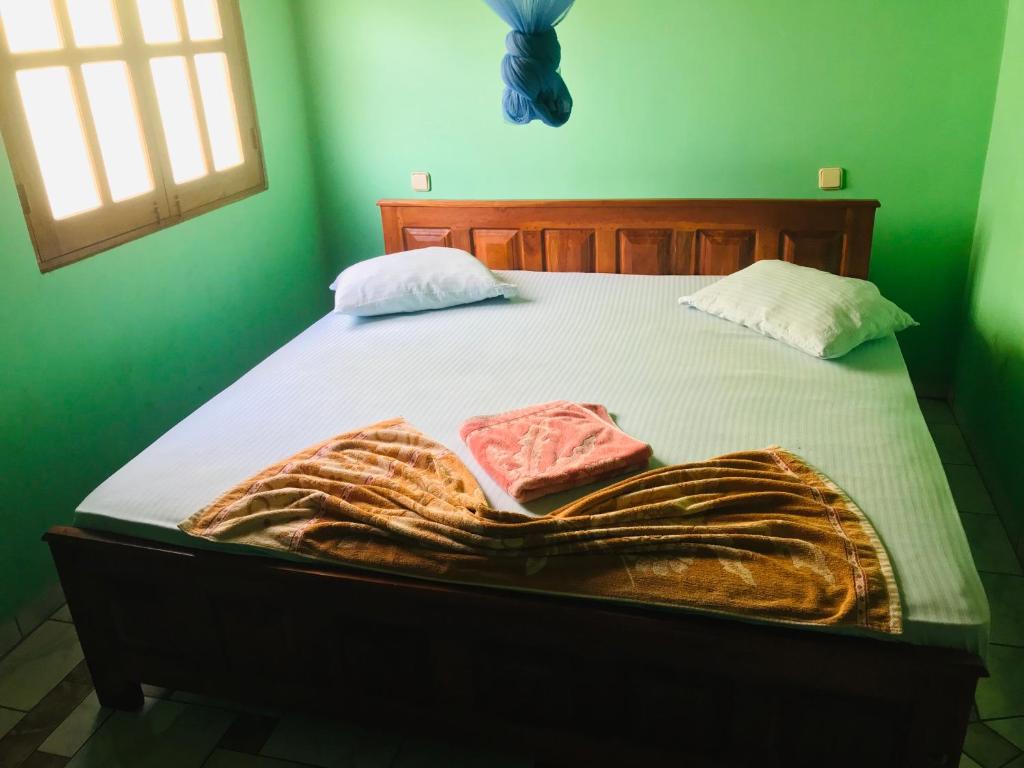 基林德Temple Flower Guest的绿色房间的一个床位,上面有毯子