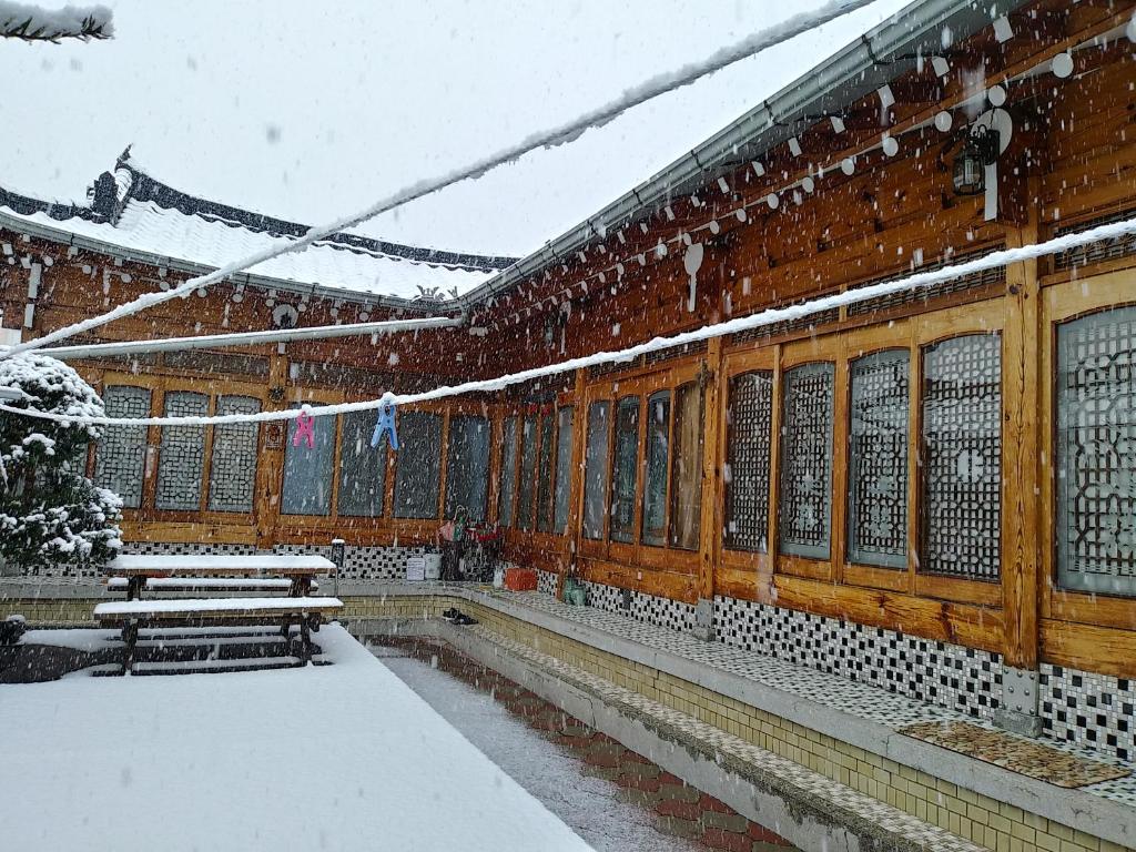 安东市Wolyeongchae的一座有长椅和窗户的雪覆盖的建筑