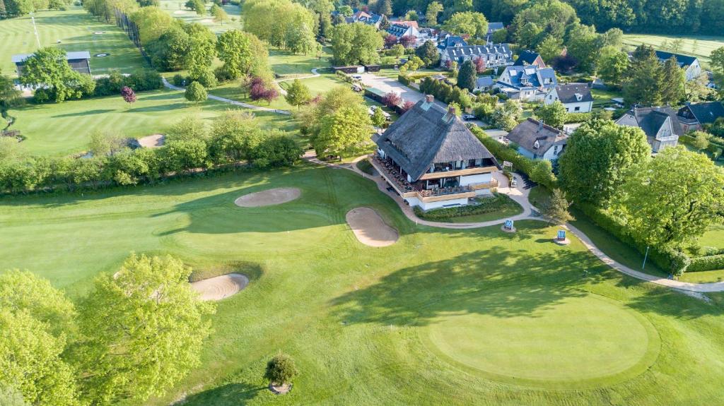 蒂门多弗施特兰德Strandgrün Golf- & Spa Resort的高尔夫球场空中景观和房子