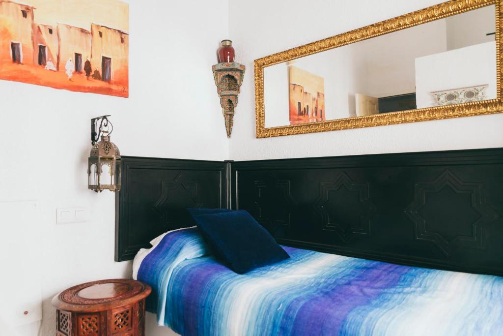 马拉加El Riad Andaluz的一间卧室配有一张床和镜子