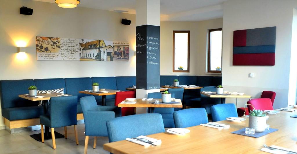 哈雷威斯特法伦霍尔曼酒店的一间配备有桌子和蓝色椅子的用餐室