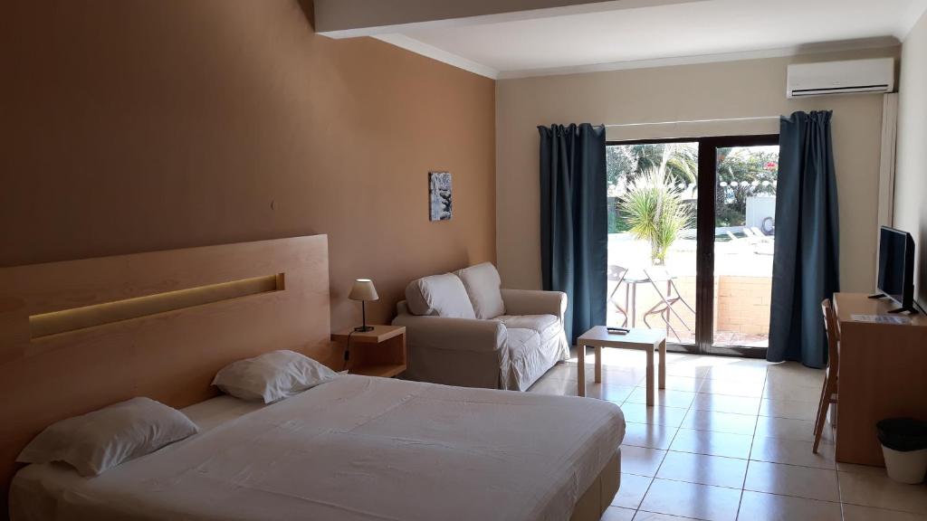 卢斯维拉马尔酒店的酒店的客房 - 带一张床、椅子和窗户