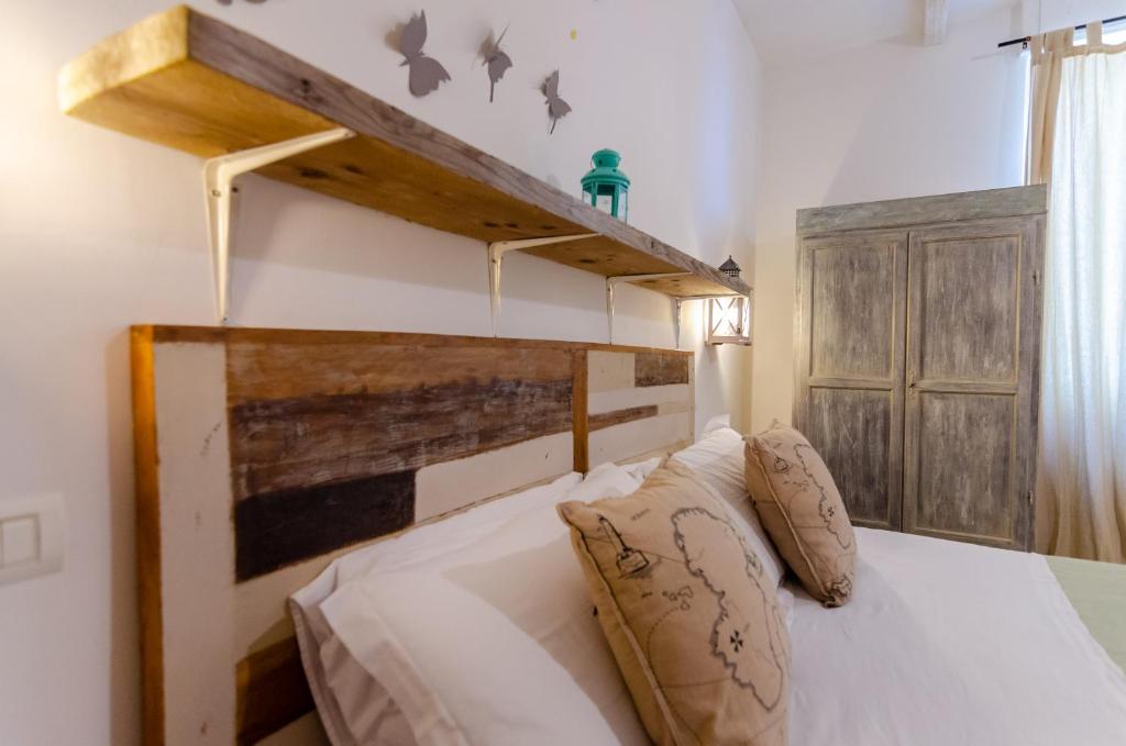 巴列塔Domatia的卧室配有白色的床和木制床头板