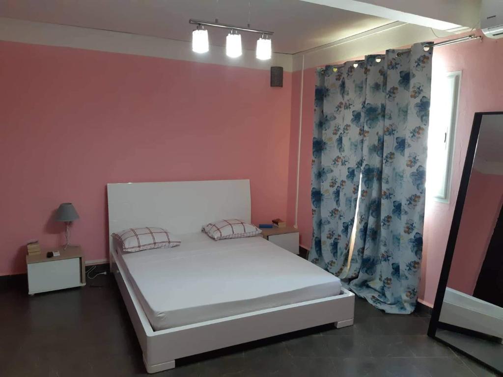 MamoudzouCACAO LODGE的一间小卧室,配有白色的床和窗户