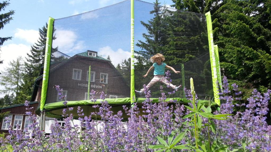 派克波特斯耐兹库德文酒店的花朵紫色的花园中,一个女孩跳上蹦床