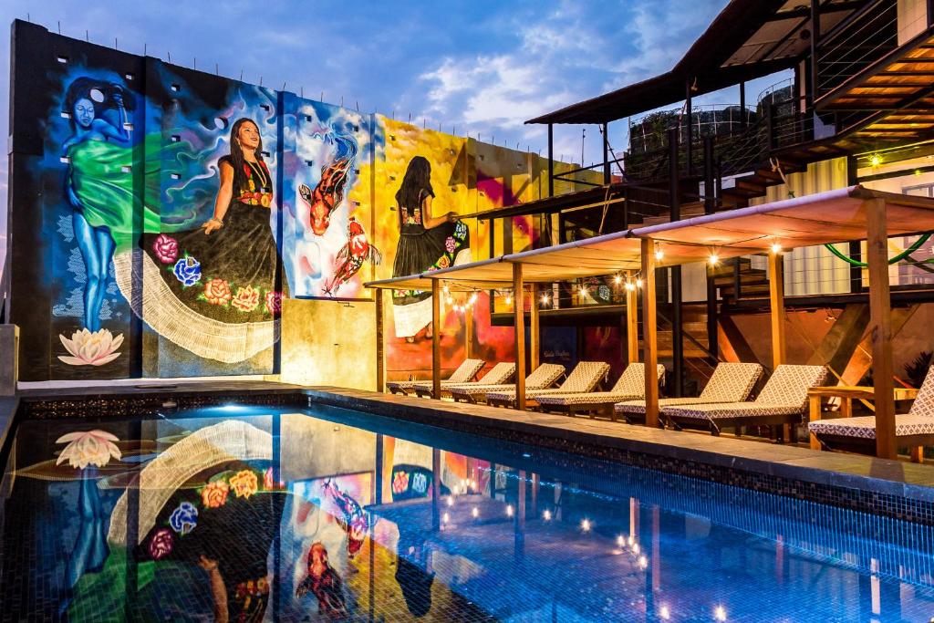 埃斯孔迪多港Cabane Container Boutique Hotel - ADULTS ONLY的一座建筑的一侧,设有一座带壁画的游泳池