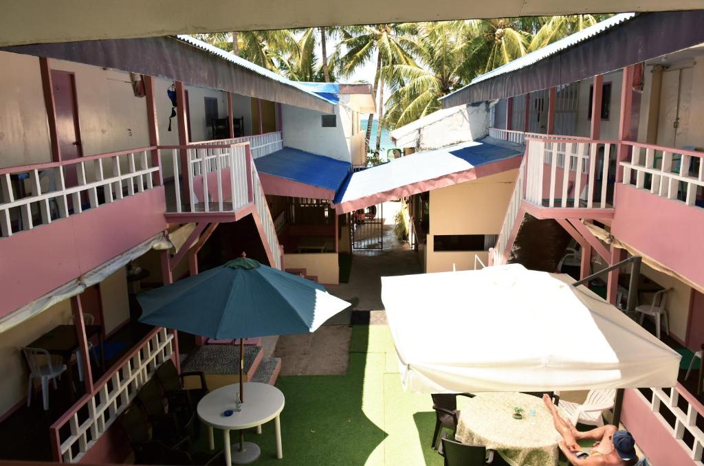 长滩岛Boracay Morning Beach Resort by Cocotel - Fully Vaccinated Staff的享有带桌子和雨伞的建筑的顶部景色
