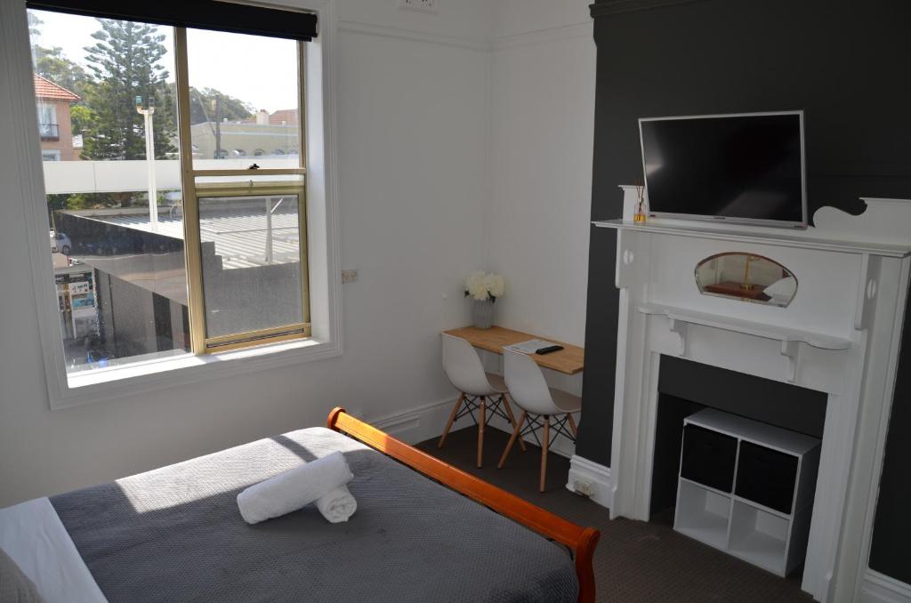 悉尼桑迪波特姆旅馆的一间卧室设有壁炉和带电视的床铺。