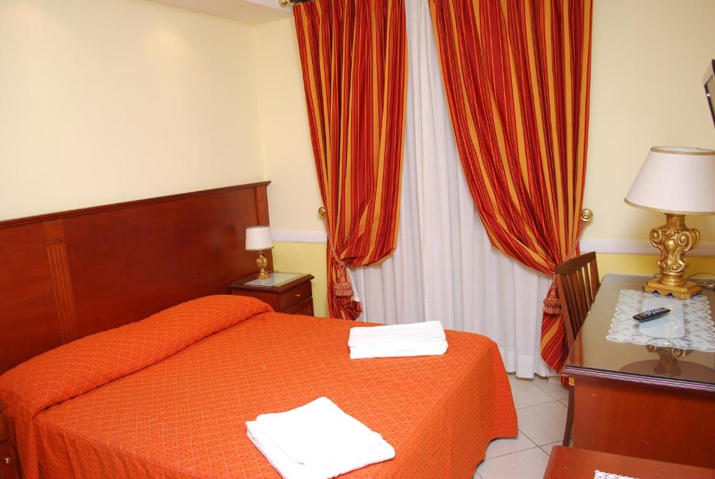 罗马华伦天奴宫酒店 的一间卧室配有一张床和一张带台灯的桌子
