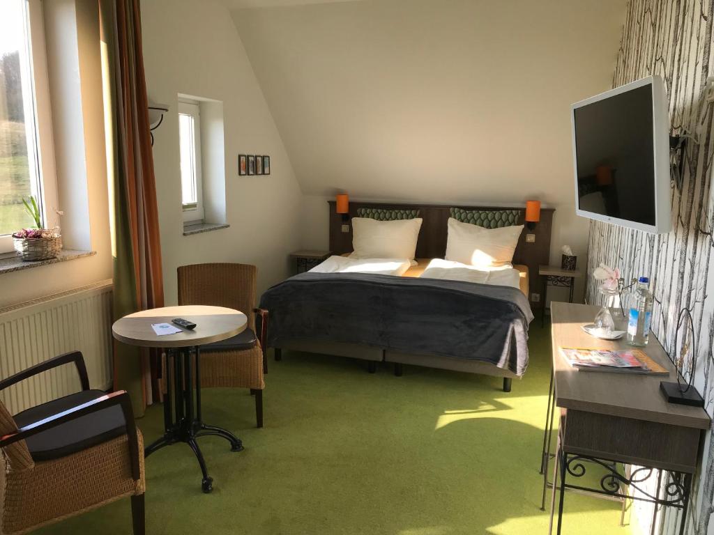 WanderslebenPension Freudenthal的一间卧室配有一张床、一张桌子和一台电视