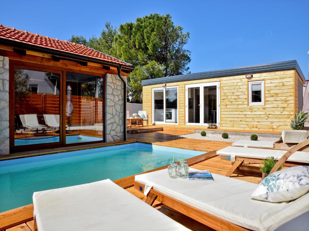 比奥格勒·纳·莫鲁Luxury mobile home Maro Biograd的一个带游泳池和房子的后院