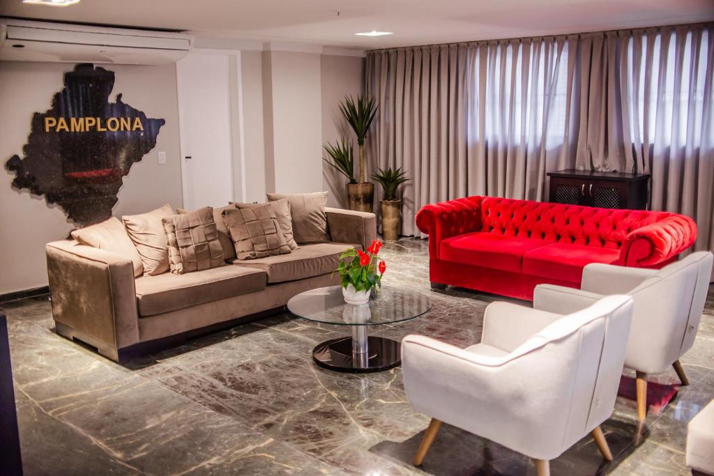 福塔莱萨Rede Andrade Casa Blanca的客厅配有红色沙发和白色椅子