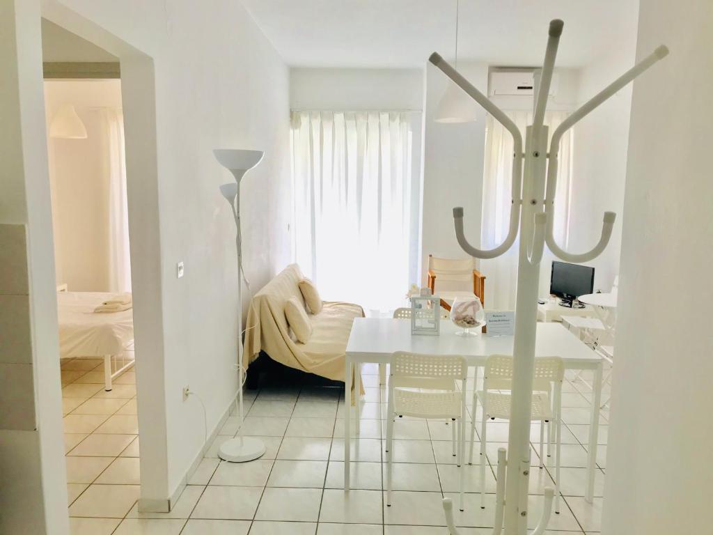 罗希姆诺Korona Beach Apartments II的白色的用餐室配有白色的桌椅