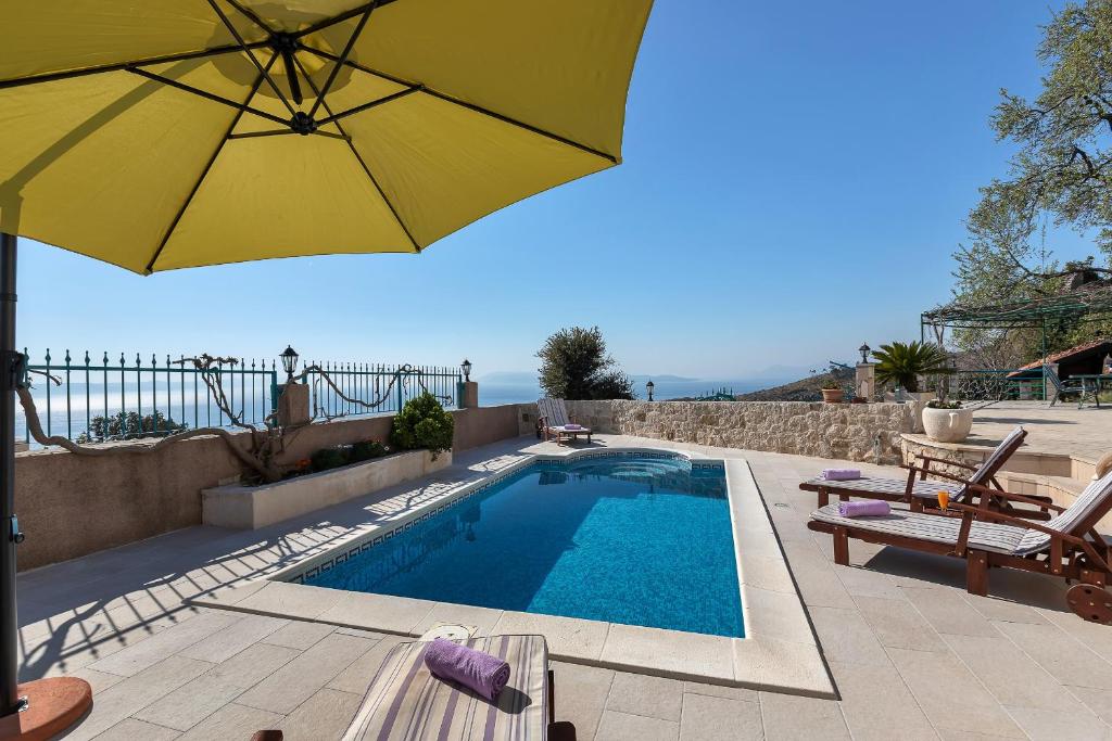伯德古拉Villa Ana的游泳池配有黄色遮阳伞和椅子